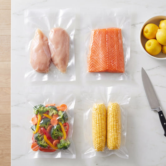 Pollo, salmón, verduras y choclos envasados al vacío en bolsas de 20 x 30 cm