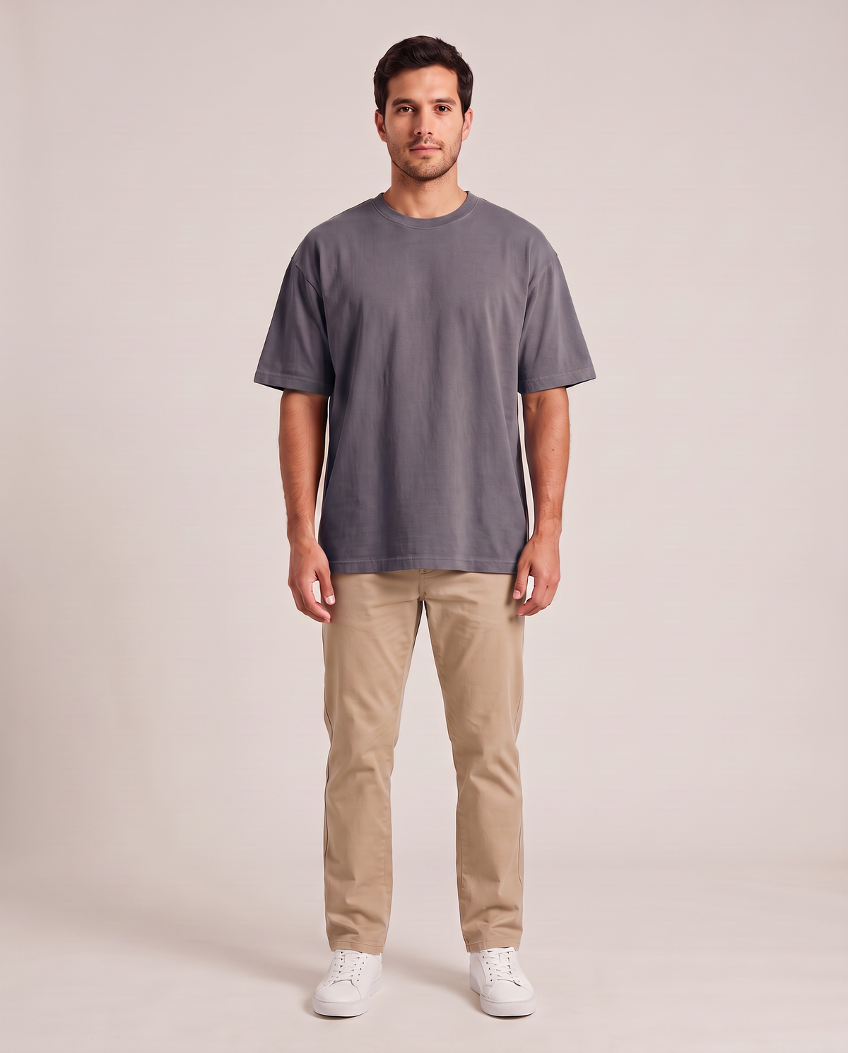 Remera oversize de hombre color gris oscuro de frente, fondo de estudio