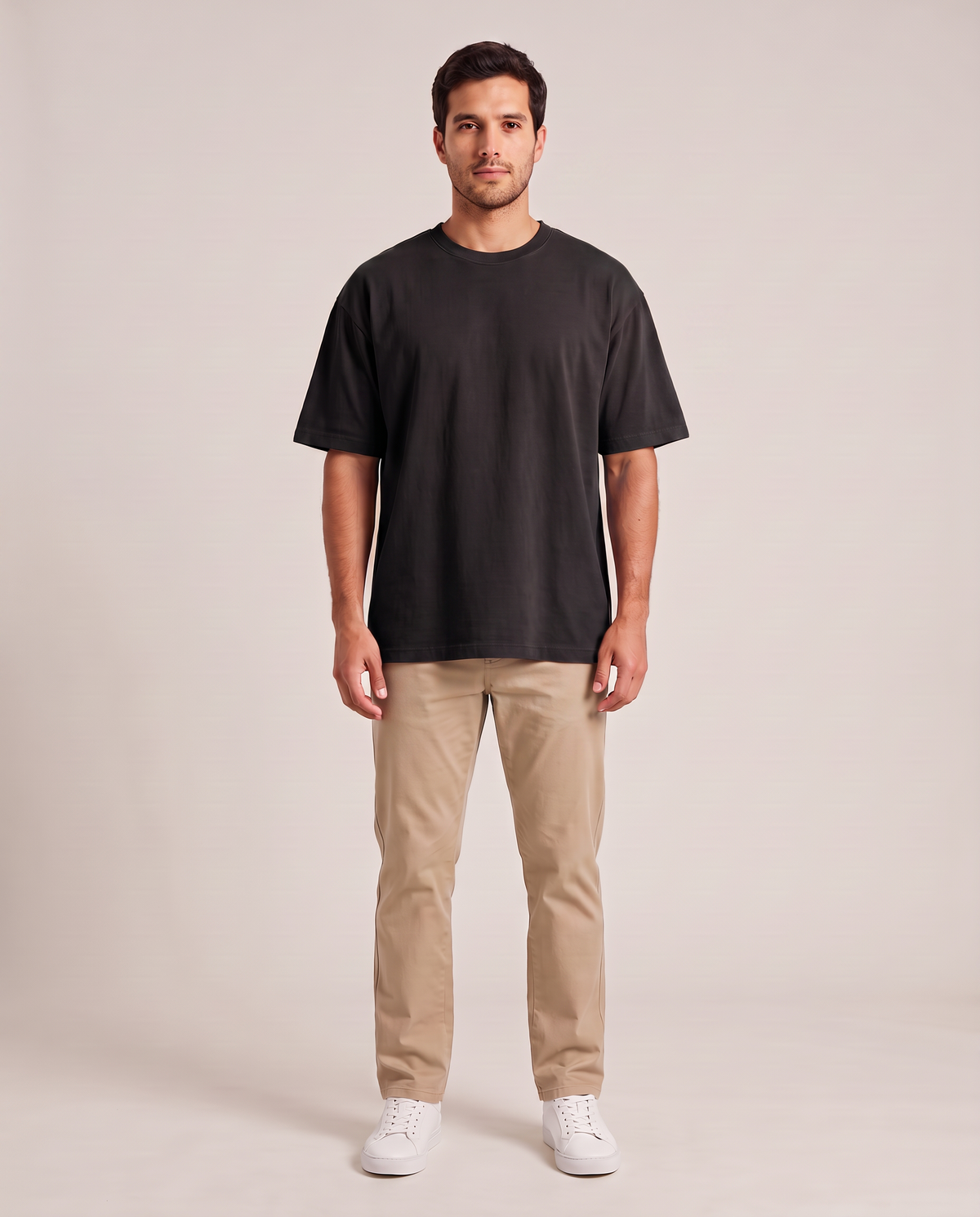 Remera oversize de hombre color negro de frente, fondo de estudio
