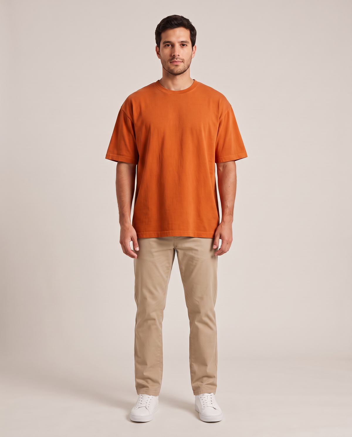 Remera oversize de hombre color naranja de frente, fondo de estudio